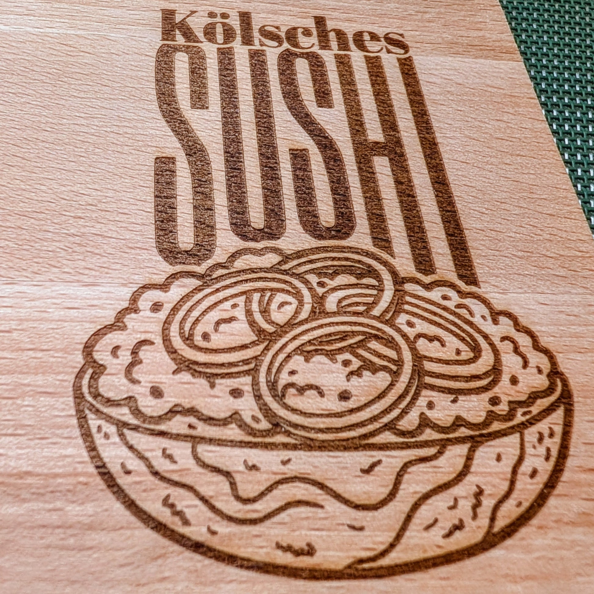 Detail der Lasergravur Kölsches Sushi auf Buchenholz Schneidebrett